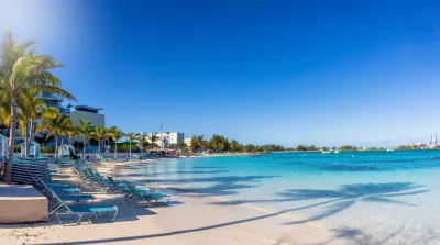 Panoramic view of the beautiful Esplanade West Beach in Nassau, Bahamas with calm turquoise sea and palm trees
