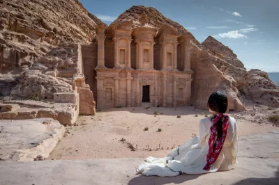 A tourist at the Al-Deir monument carved out of a rock in the ancient city of Petra, Jordan