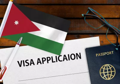 Die jordanische Flagge, das Visumantragsformular und der Reisepass liegen auf dem Tisch